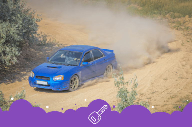 a blue car driving on a dirt road
