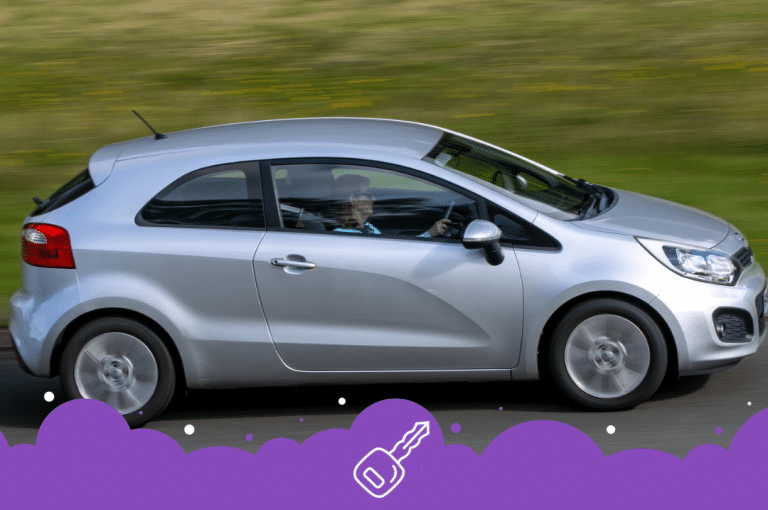 Silver Kia rio driving on the road