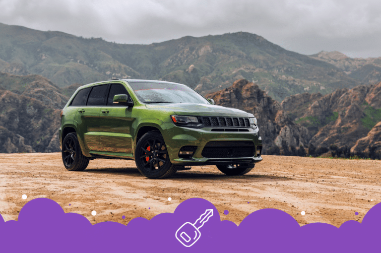 Green jeep grand Cherokee parked infront of mountains