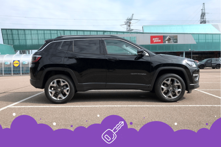 Black Jeep compass in a parking lot