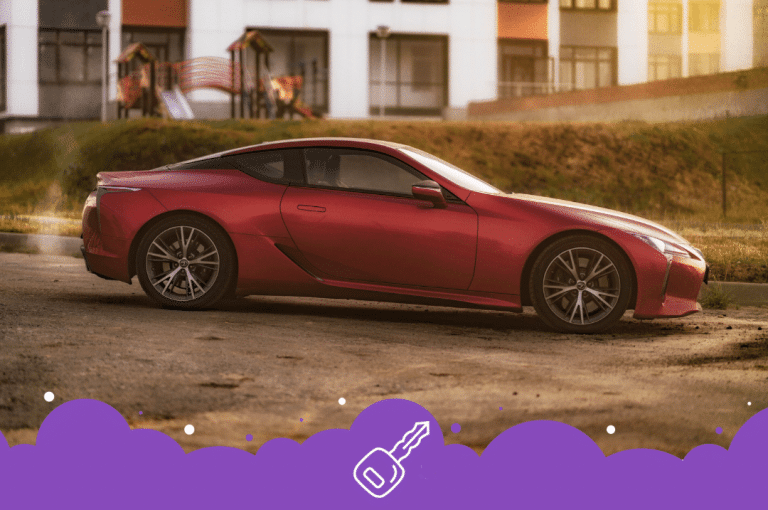 a red Lexus car parked on a dirt road