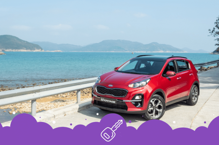 Red Kia sportage parked infront of the coast