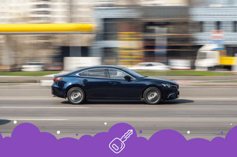 a blue car driving on a road