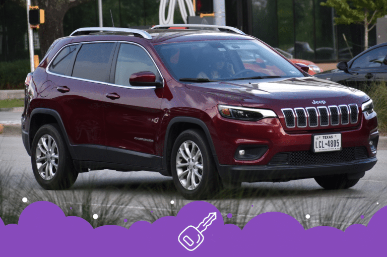 Maroon Jeep Cherokee driving on the road