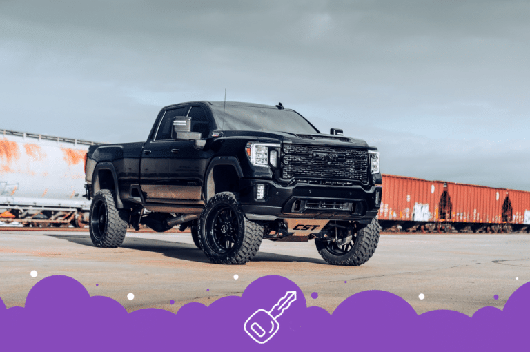 Black gmc sierra infront of trains