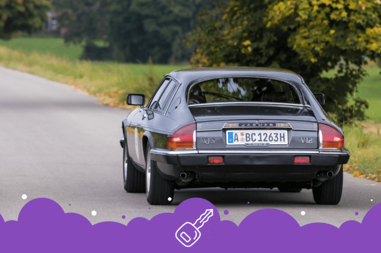 Gray jaguar xjs driving down the road