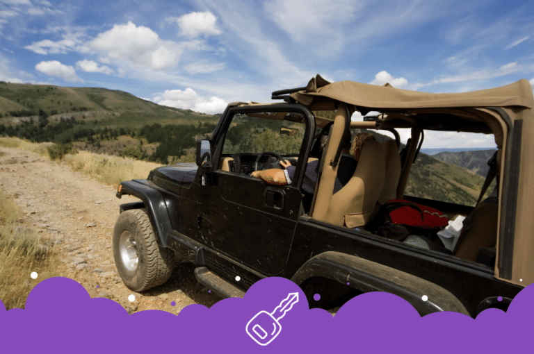 Side shot of a black Jeep wrangler driving on dirt road