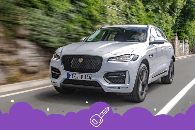 Grey jaguar f pace driving down road blurry background
