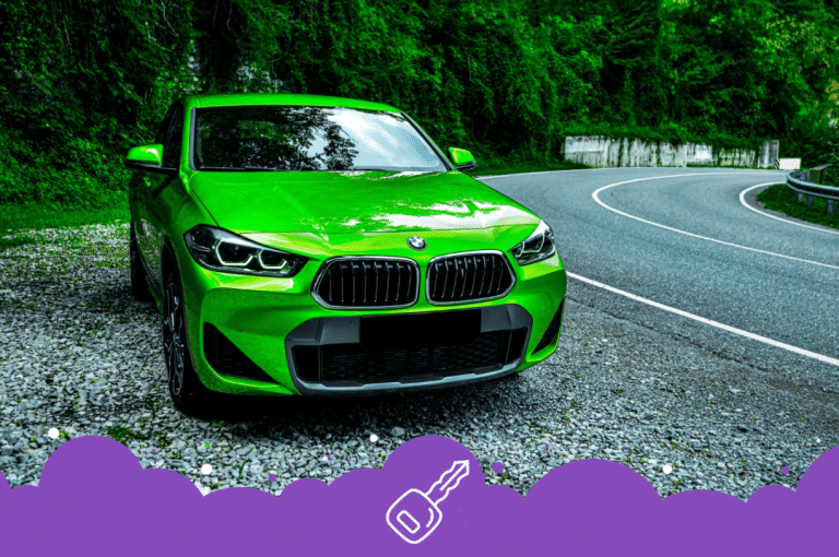 Green bmw x2 parked by trees