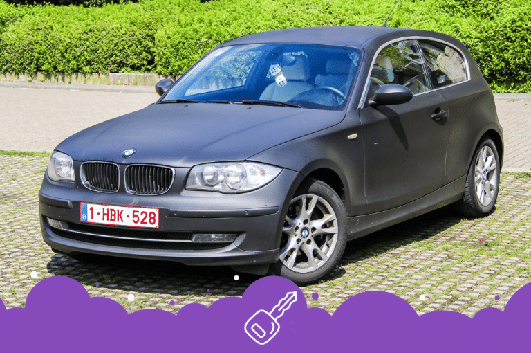 Grey bmw 1 series parked with bushes behind