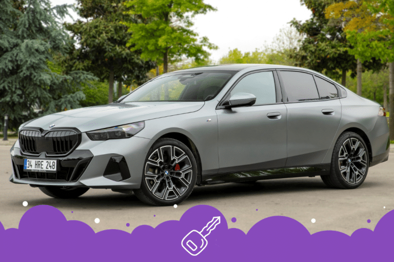 Grey bmw 5 series parked infront of trees