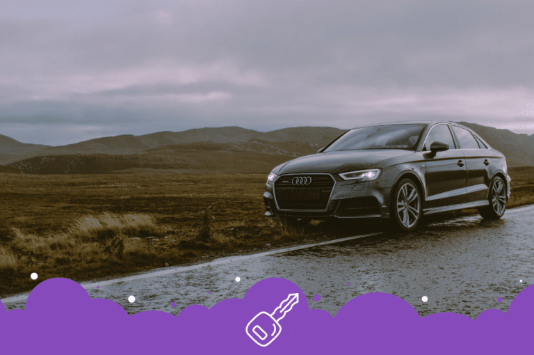 Grey Audi car pulled over on side of highway hills in the back