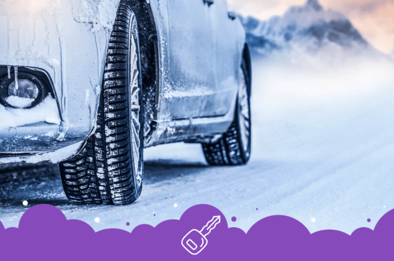 Close up of bottom half of suv in winter with mountain in the background