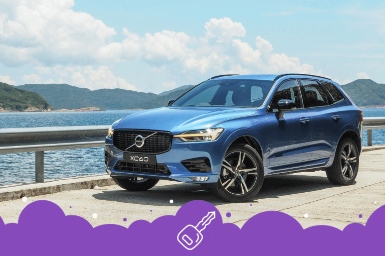 Blue Volvo xc60 infront of water and hills on bridge