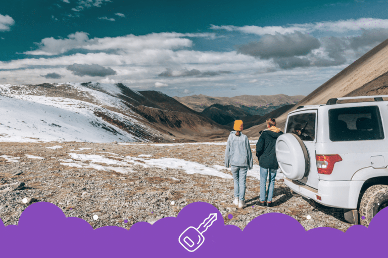 2 people looking at mountain range with white suv