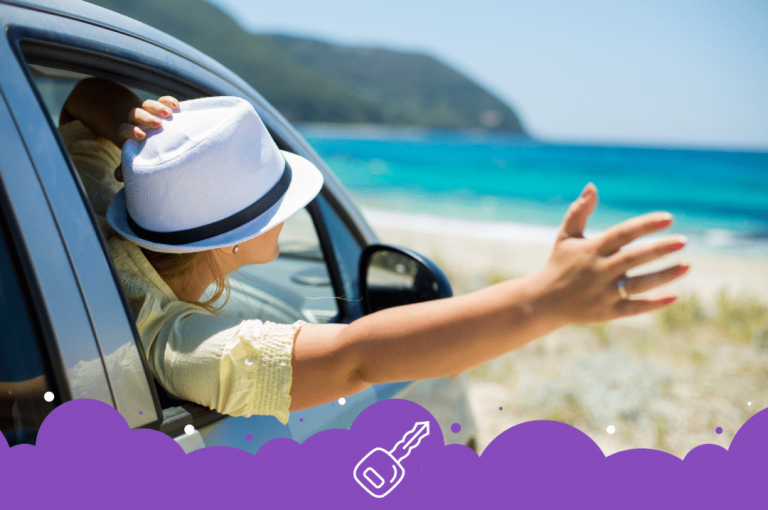 Person with their hand out the window at the beach
