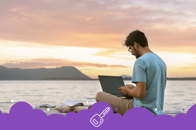 Guy working on laptop by mountain lake