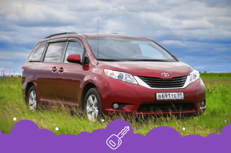 Red Toyota sienna parked on grass
