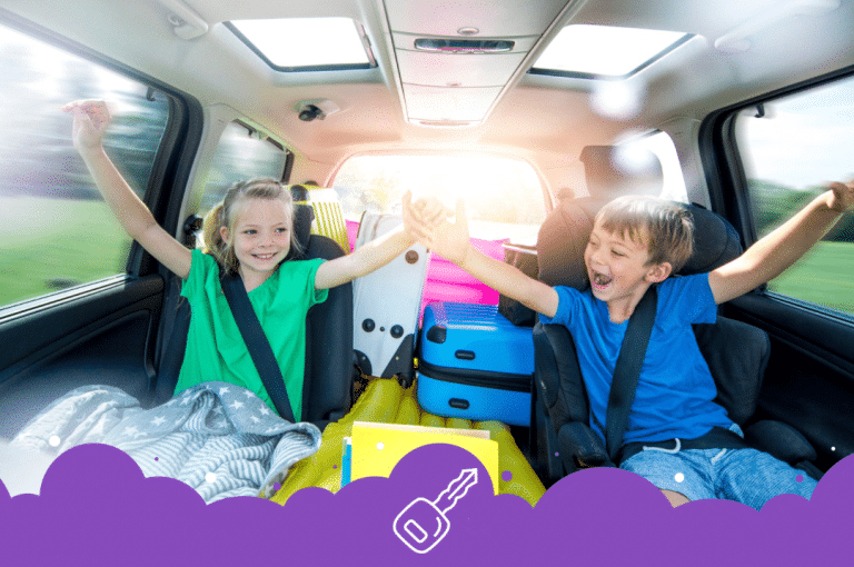 2 kids in the back of mini van with luggage ready for road trip