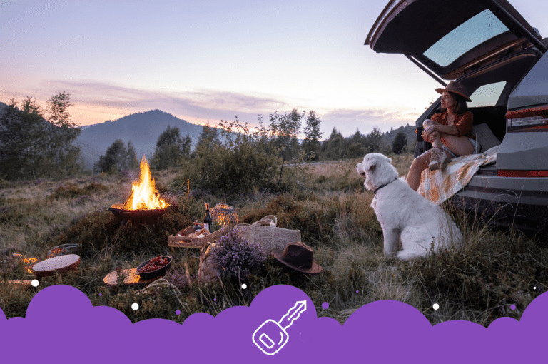 Dog and woman enjoying sunset by fire and back of car